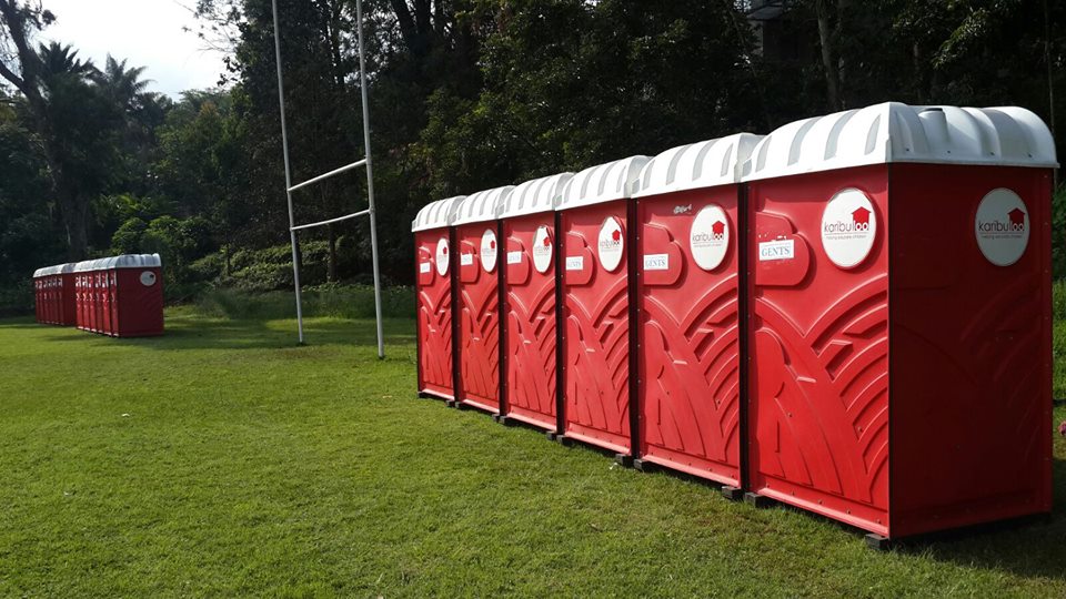 A row of portable toilets neatly arranged on a school, providing convenient and hygienic restroom facilities for students and staff